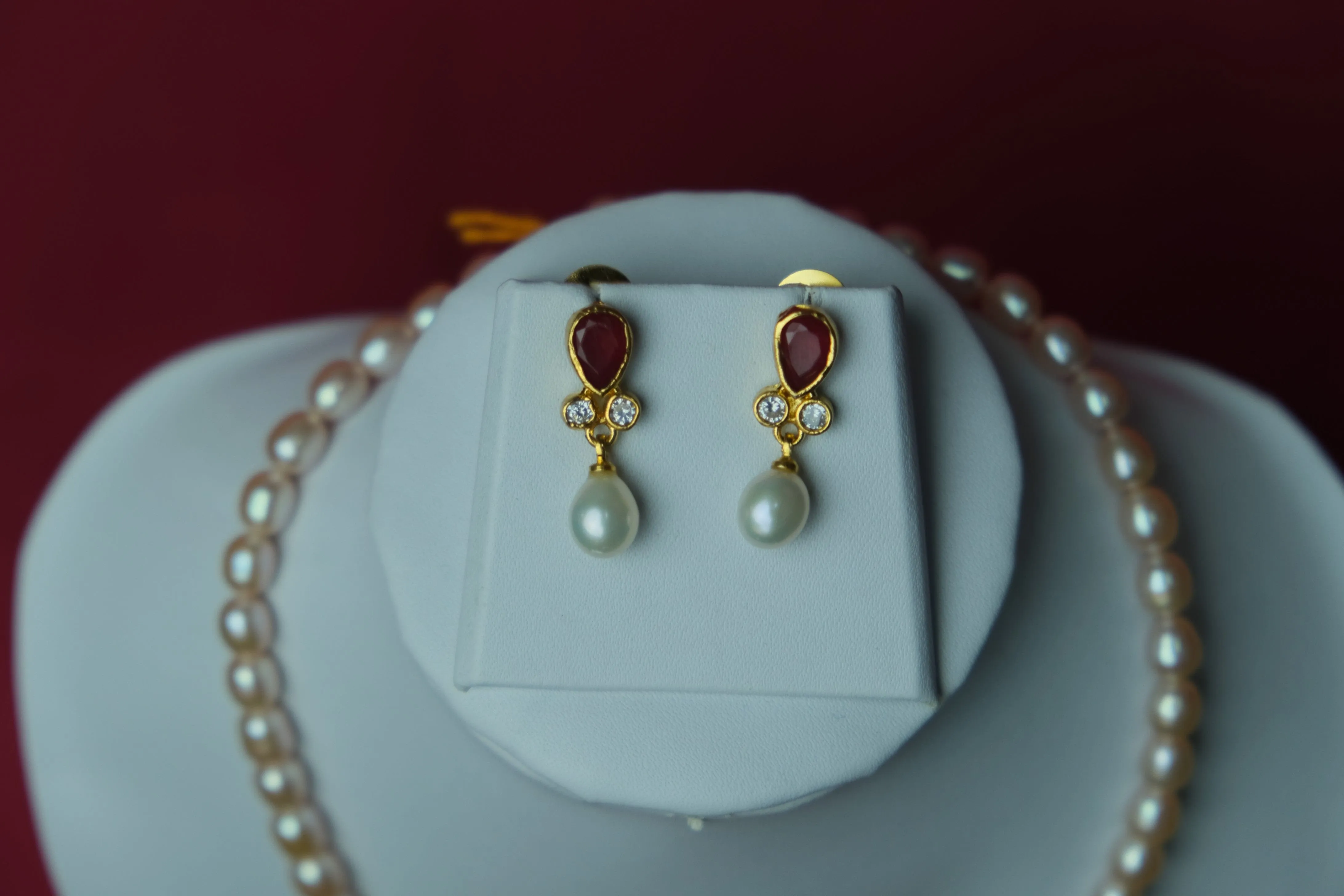 Cream color oval shape single line medium size fresh water cultured pearl necklace with pearl pendent along with jhumkas.